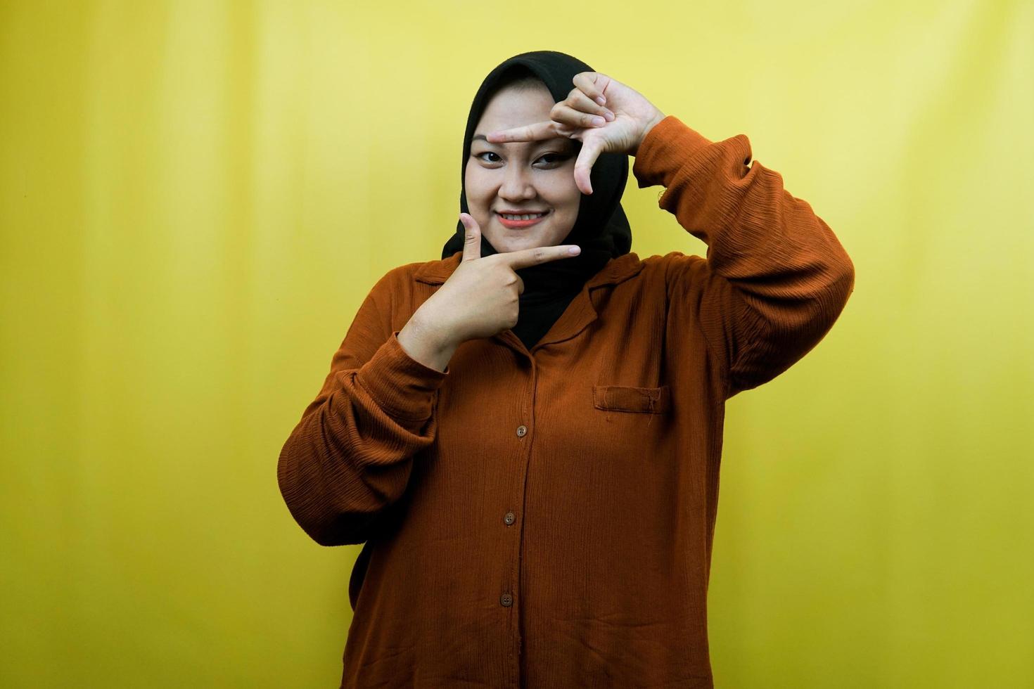 linda e alegre jovem muçulmana asiática com gesto de retrato de câmera, isolada foto