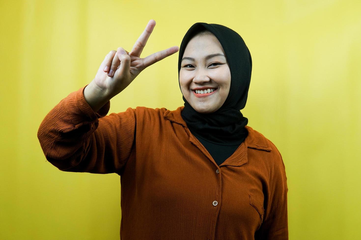 linda jovem muçulmana asiática com mãos assinadas com V, ok, bom trabalho, acordo, vitória, olhando para a câmera isolada foto