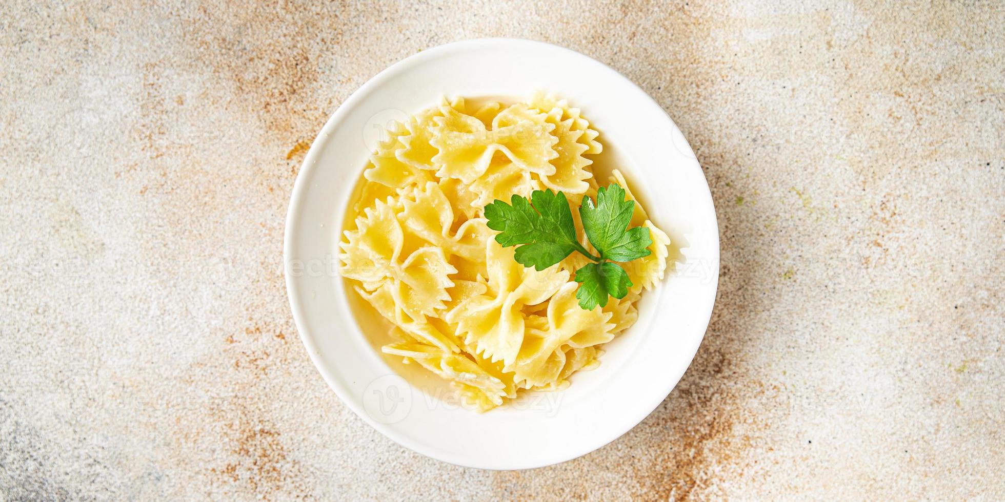 Arcos de trigo duro de macarrão farfalle formam uma refeição de fundo foto