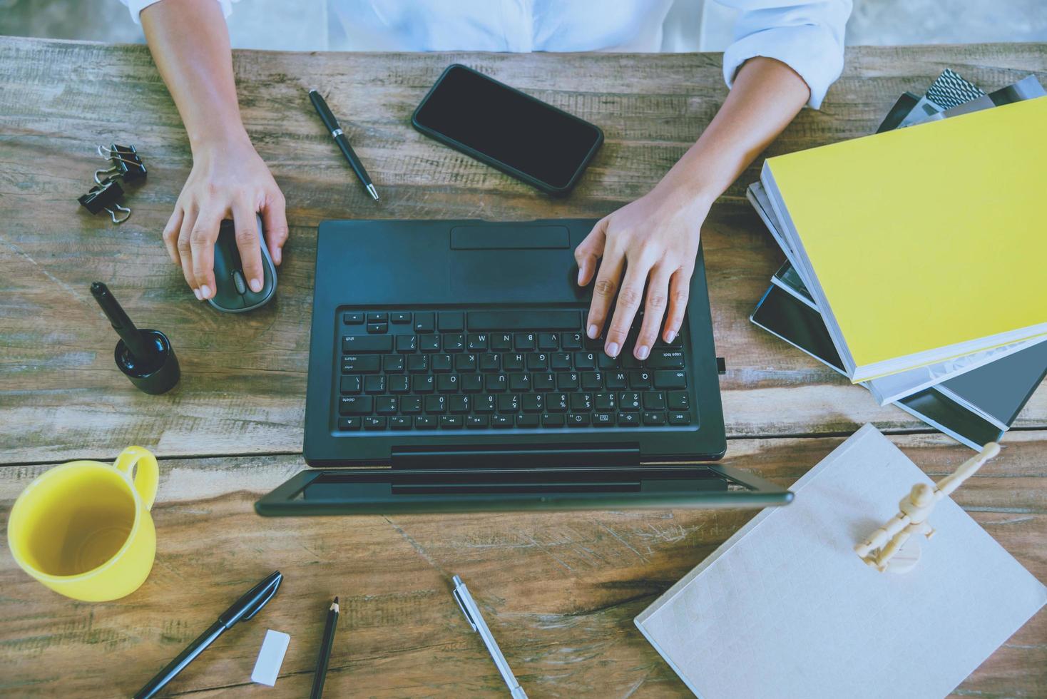 mulheres sentadas trabalhando na mesa de madeira, trabalhando com um notebook e bebem café em casa. no feriado foto