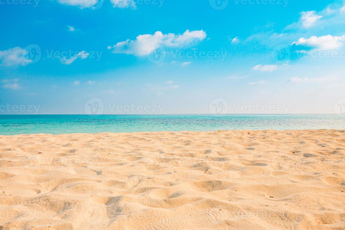 close up de areia na praia e céu azul de verão. paisagem panorâmica da praia. praia tropical vazia e vista do mar. céu alaranjado e dourado do pôr do sol, areia fofa, calma, luz solar tranquila e relaxante, clima de verão foto