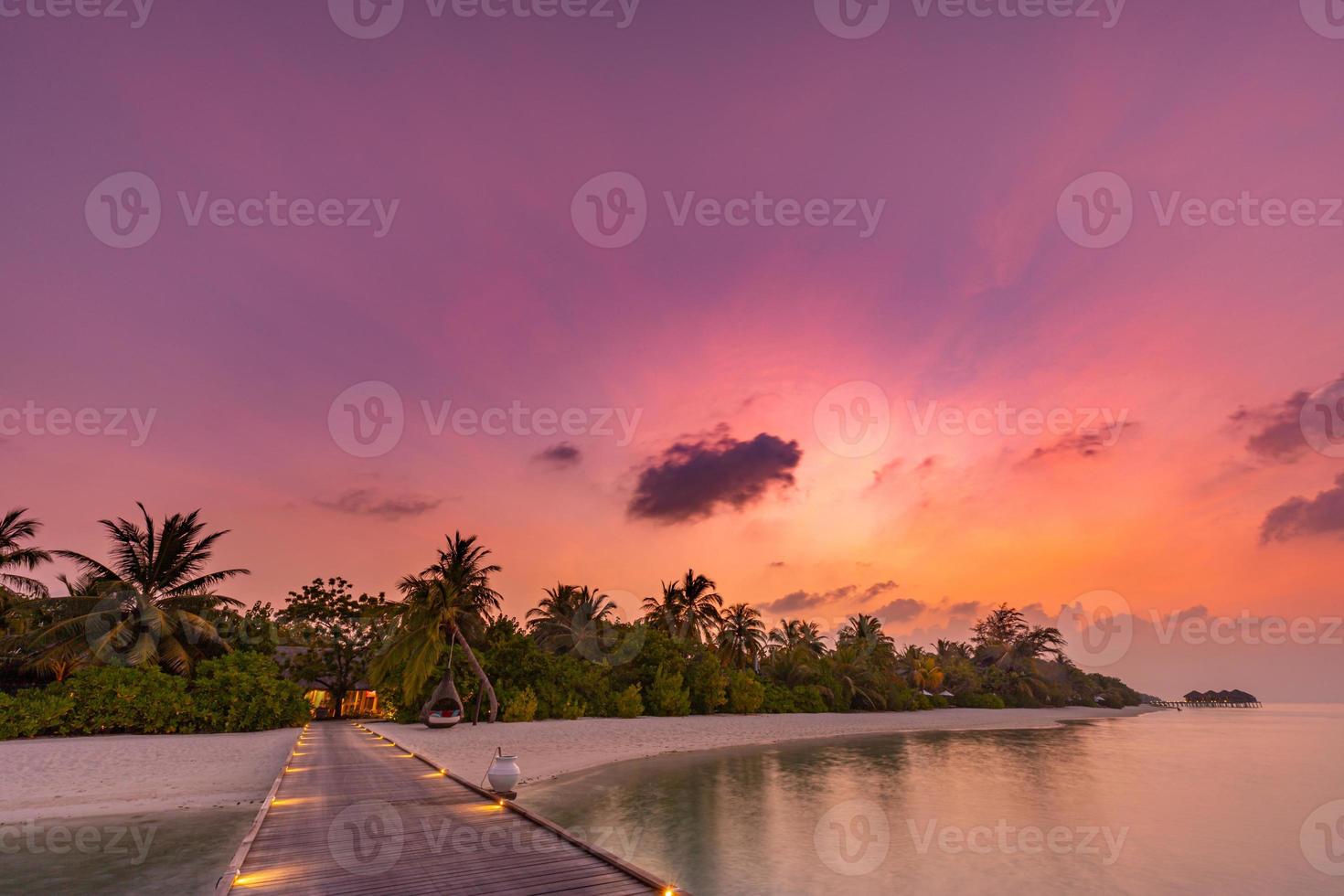 pôr do sol na ilha das Maldivas, resort de villas luxuosas na água e cais de madeira. lindo céu, nuvens e fundo de praia para férias de verão, férias e conceito de viagens foto