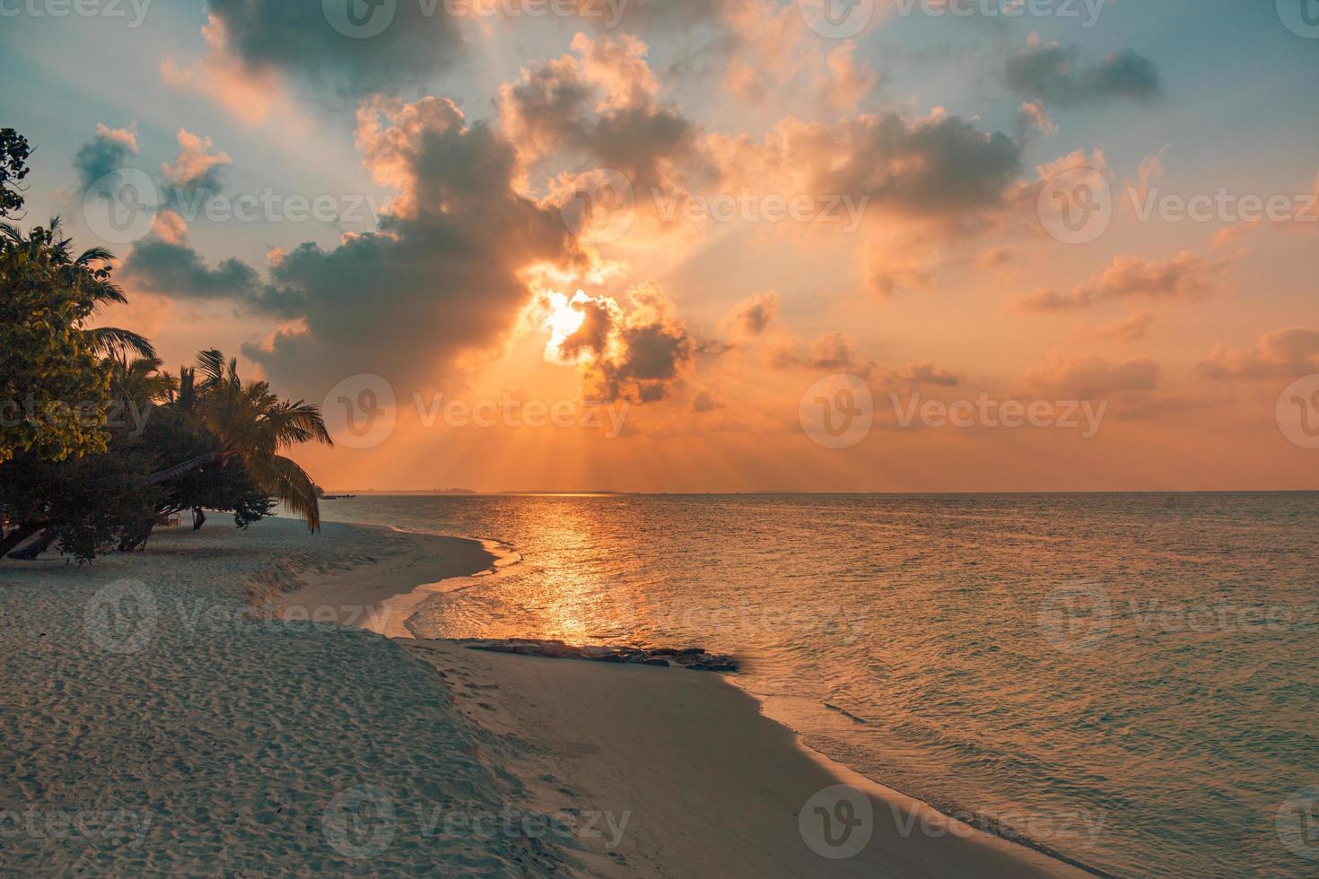 fantástica cena de praia do sol. céu colorido e nuvens vista com mar calmo e clima tropical relaxante. raios de sol, paisagem de ilha paradisíaca romântica, silhueta de palmeiras, noite de praia incrível foto
