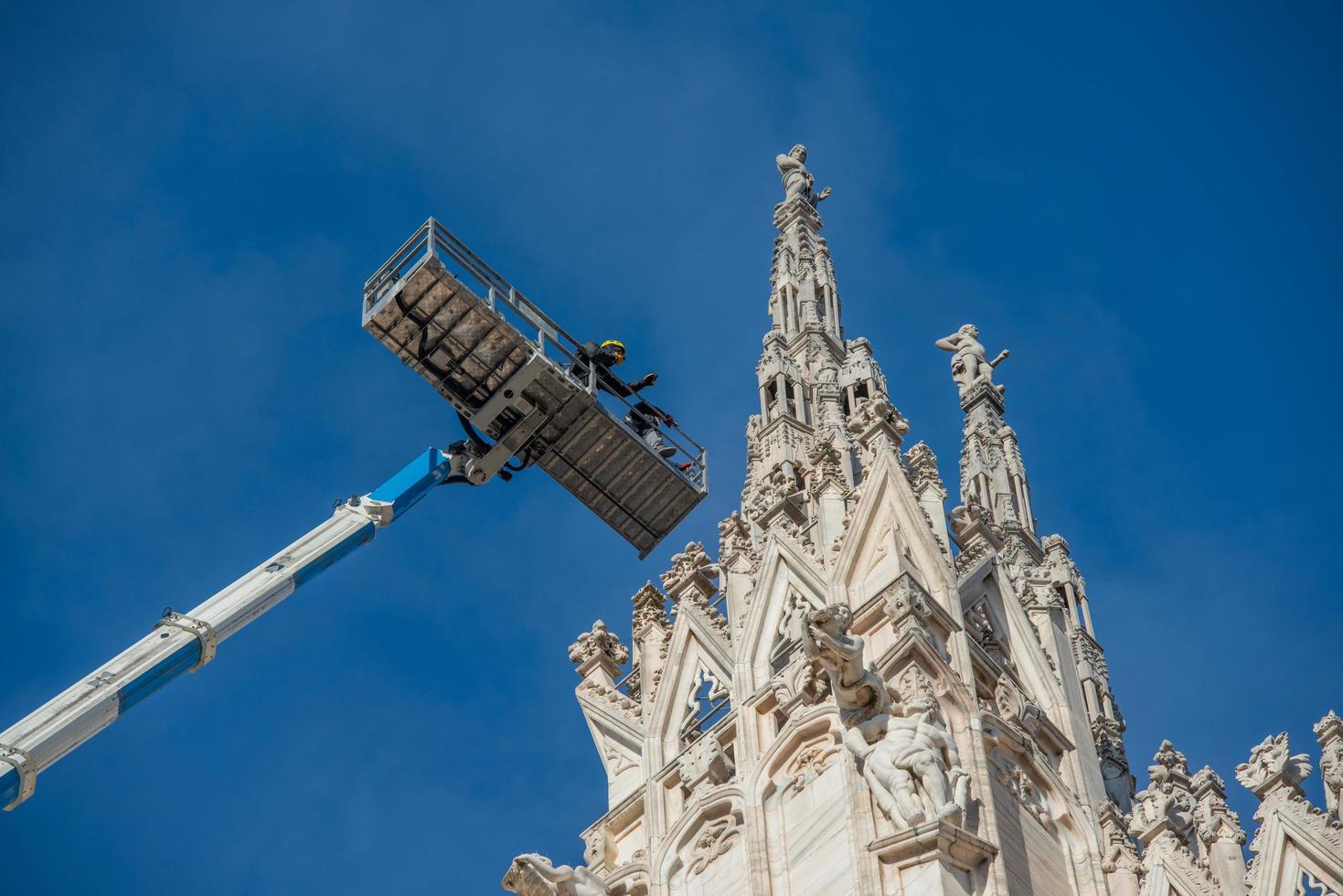 milão itália 2021 técnicos em plataforma elevatória para plano de manutenção programada e estudo dos fenômenos de degradação da catedral de milão foto