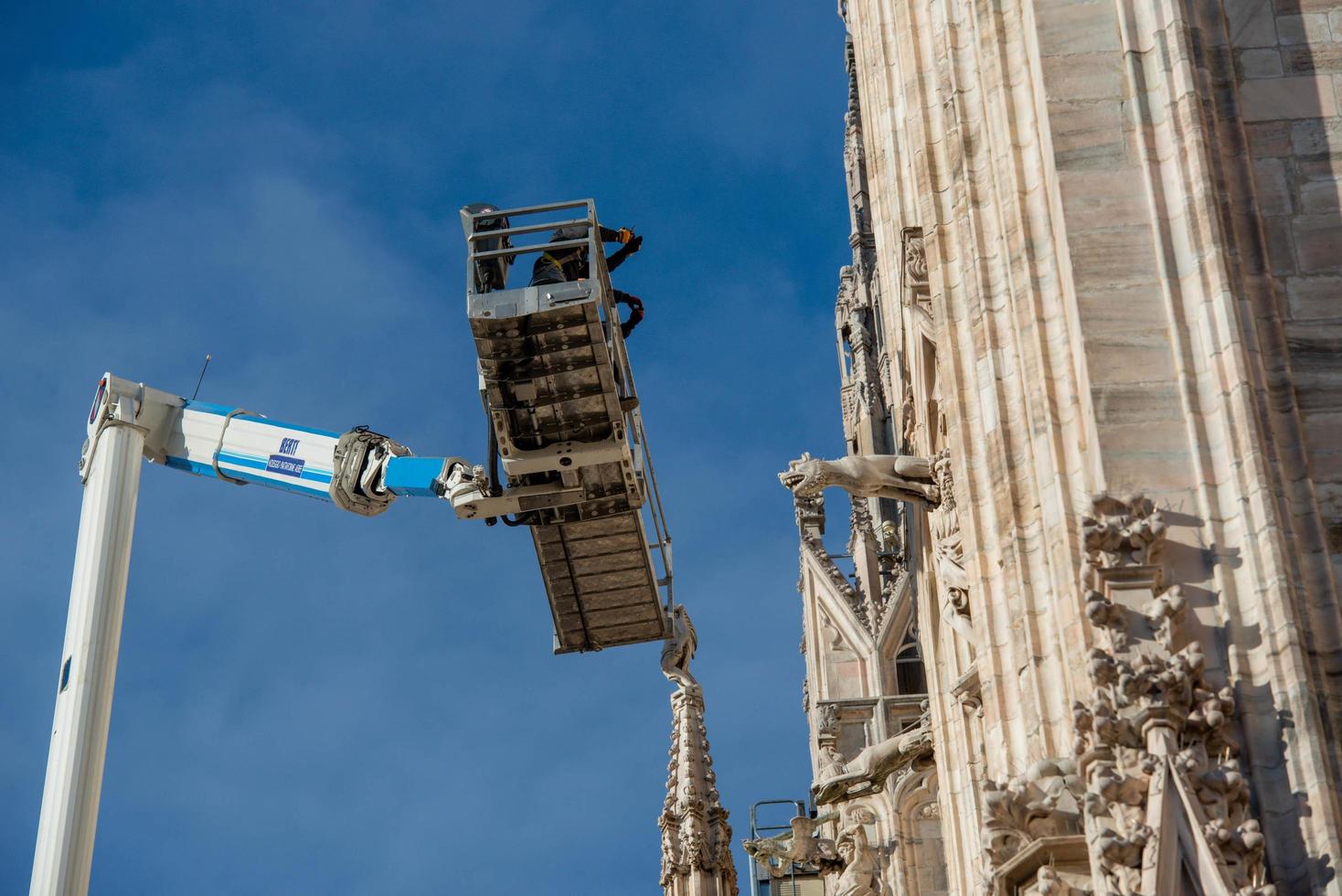 milão itália 2021 técnicos em plataforma elevatória para plano de manutenção programada e estudo dos fenômenos de degradação da catedral de milão foto