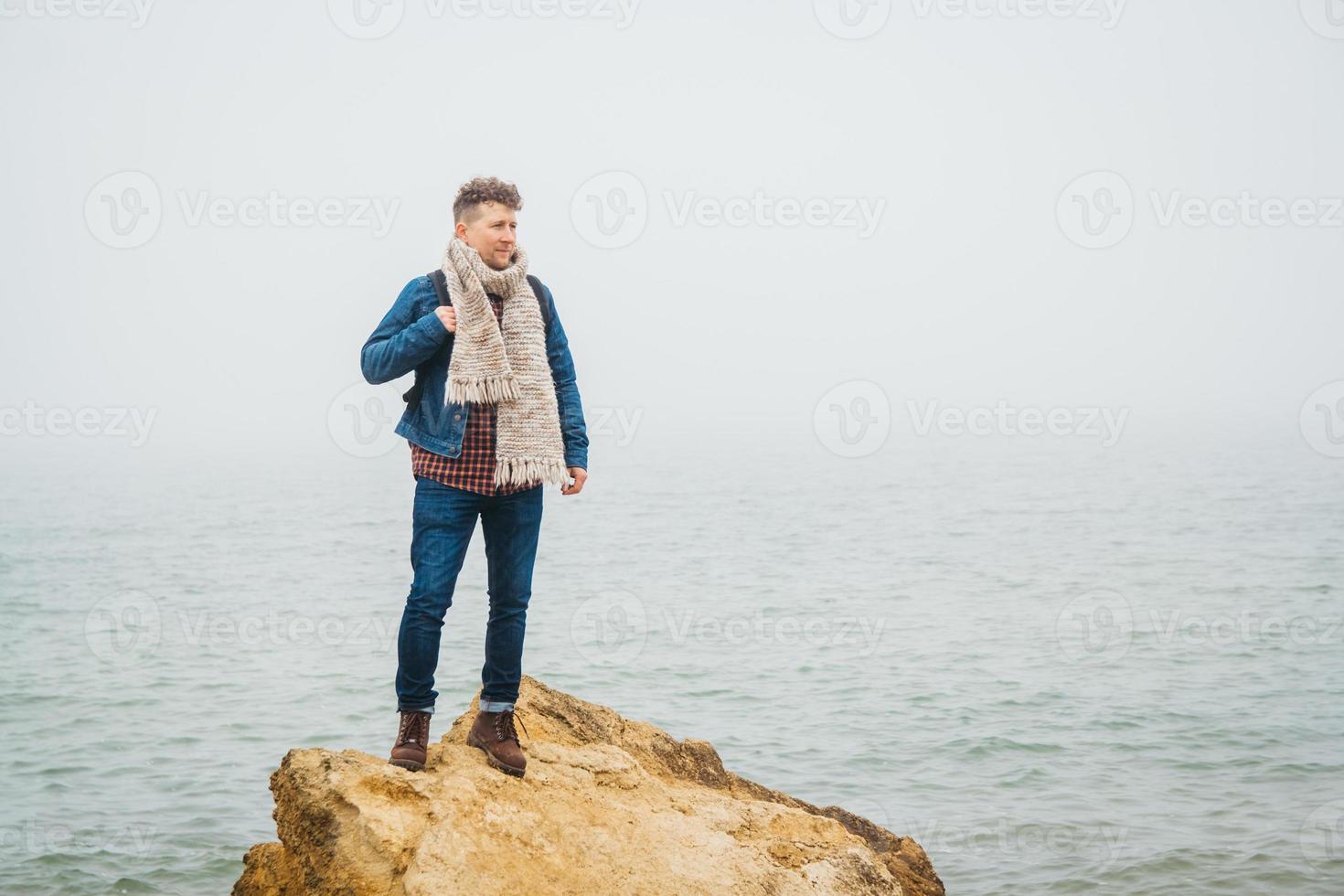 homem viajante fica em uma rocha no fundo um lindo mar foto