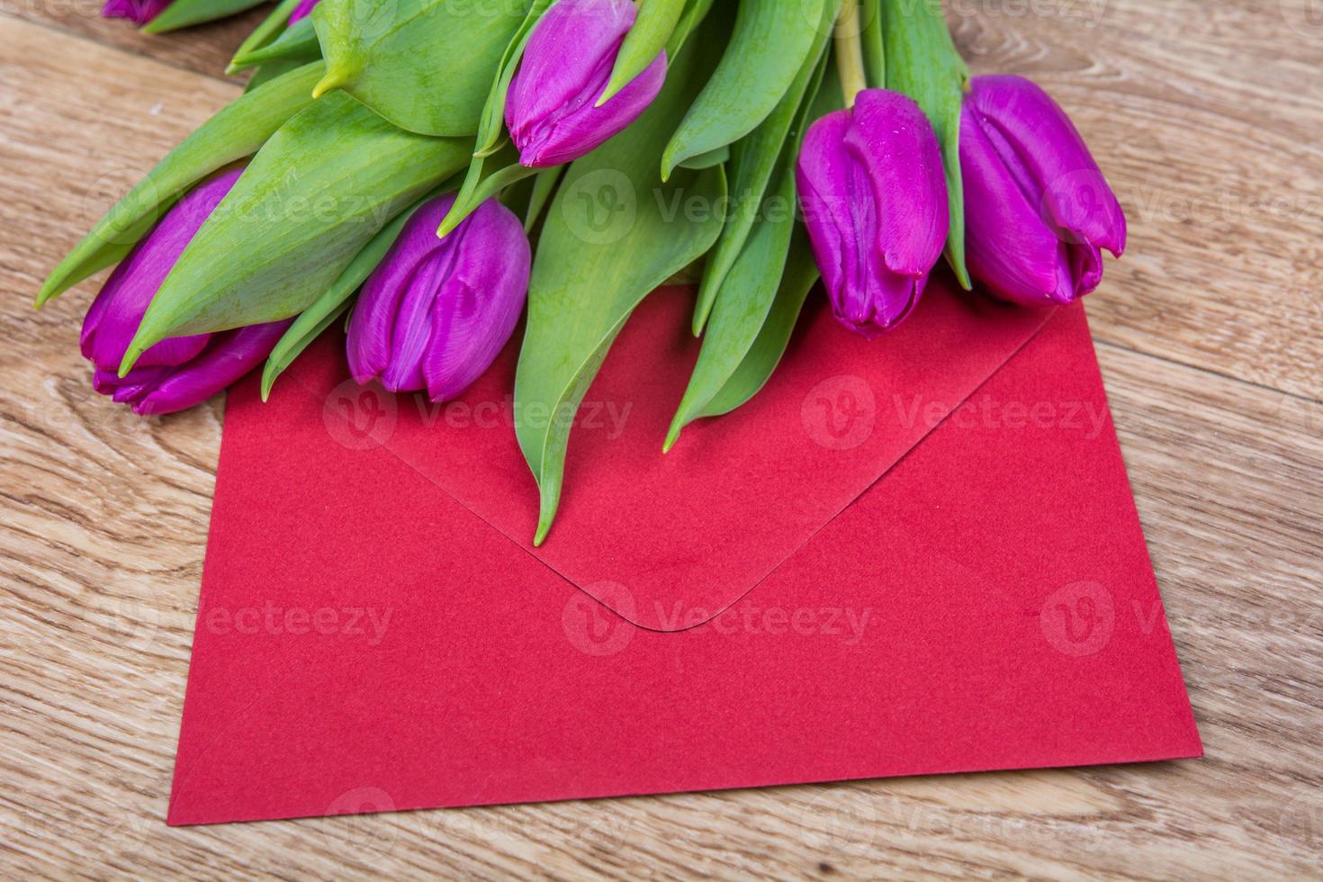 envelope vermelho com tulipas em uma mesa foto