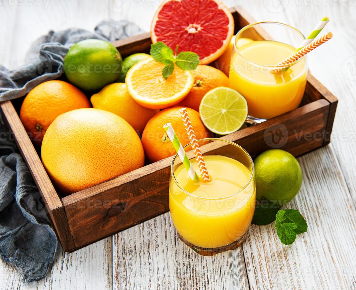 copos de suco e frutas cítricas foto