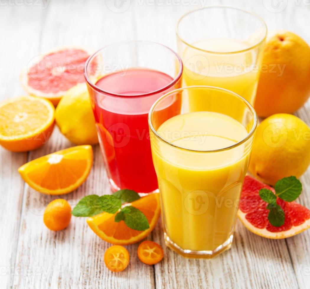 copos de suco e frutas cítricas foto