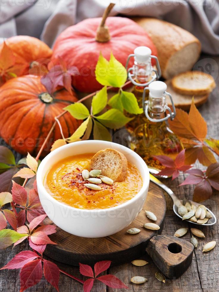 tigela de sopa de abóbora em fundo de madeira rústico foto