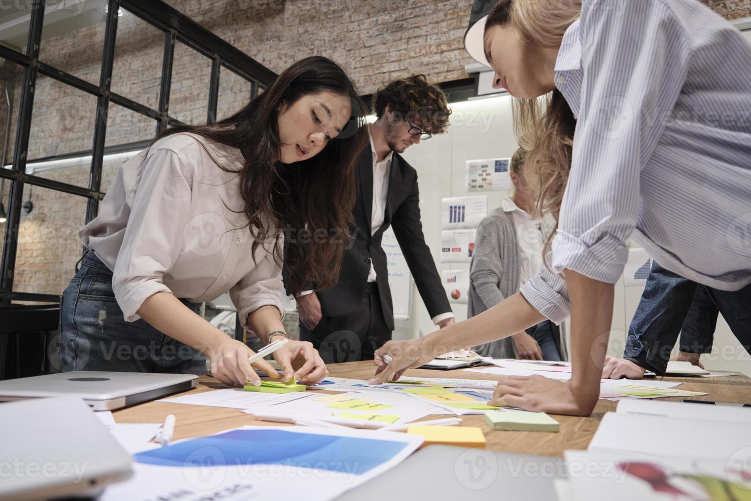 a equipe de colegas de trabalho e o colega fizeram um brainstorm, discutindo uma estratégia de marketing, colaboração de ideias e planejamento de projeto de negócios em uma mesa de conferência de escritório no local de trabalho de reunião de equipe. foto