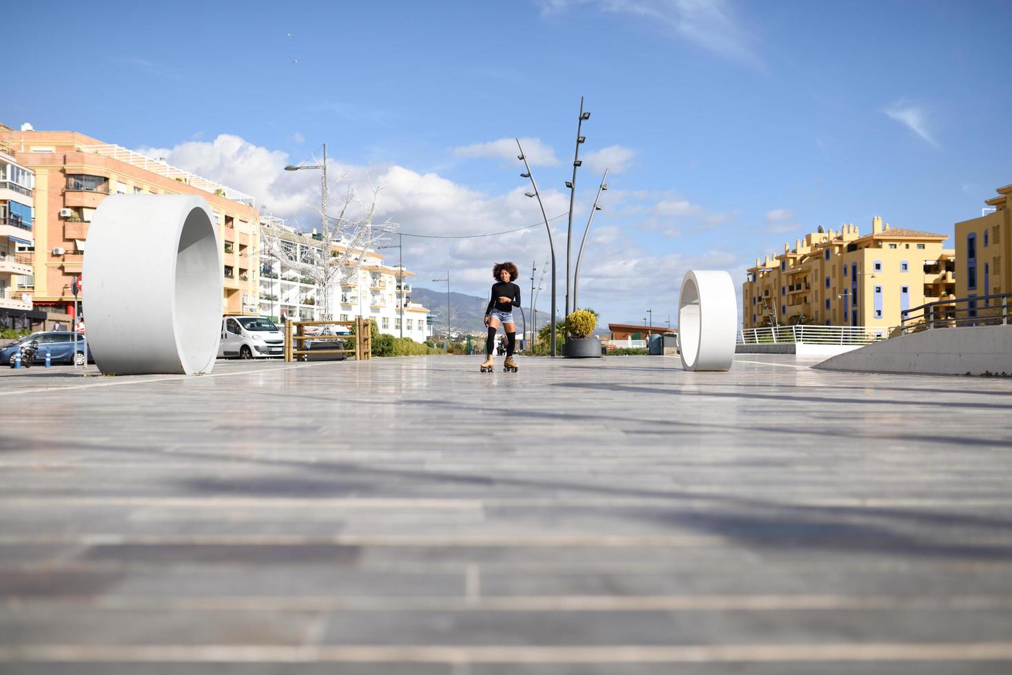 mulher negra de patins, andando ao ar livre em uma rua urbana foto