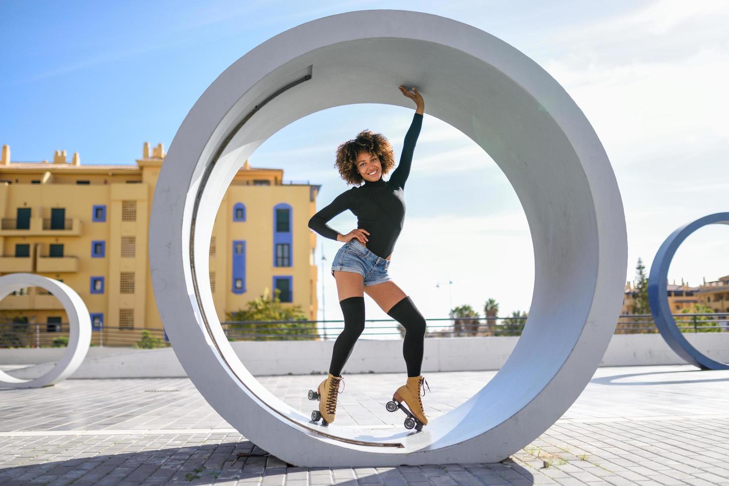 mulher negra de patins, andando ao ar livre em uma rua urbana foto