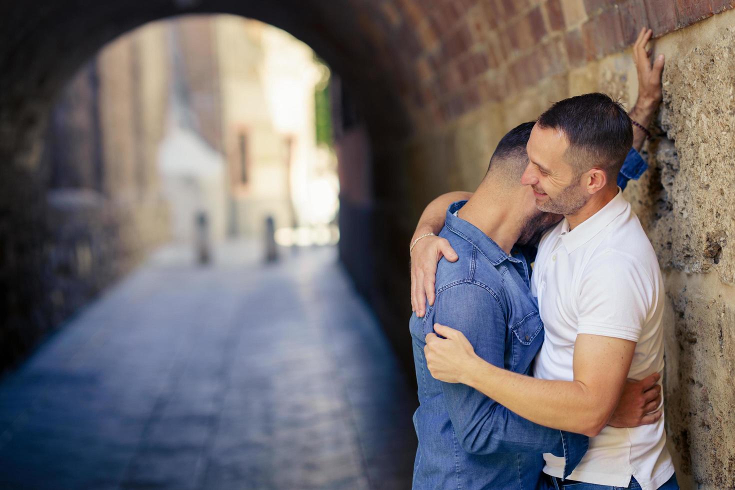 casal gay se abraçando em um momento romântico ao ar livre foto