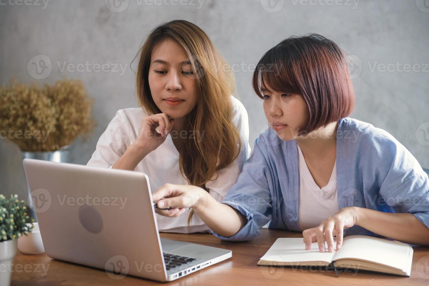 duas mulheres de negócios jovens sentadas à mesa no café. mulheres asiáticas usando laptop e café. freelancer trabalhando em uma cafeteria. trabalhando fora do estilo de vida do escritório. reunião individual. foto