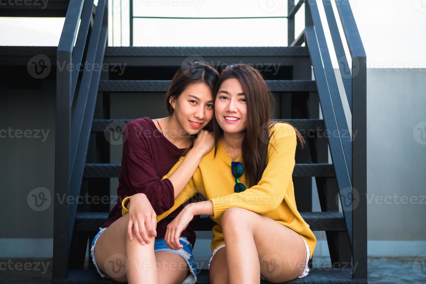 lgbt mulheres lésbicas casal momentos de felicidade. mulheres lésbicas casal juntos conceito ao ar livre. casal de lésbicas abraçou relação se apaixonar. duas mulheres asiáticas se divertindo juntos no telhado. foto