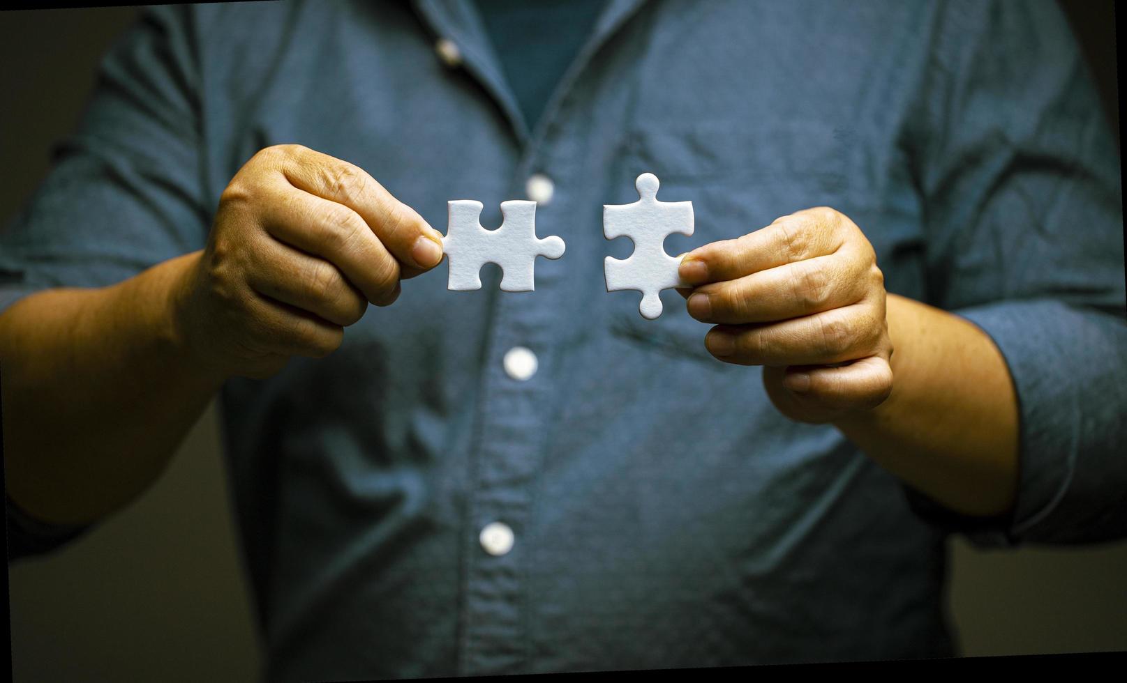 mão do homem conectando o quebra-cabeça. soluções de negócios e conceito de sucesso. rede, estratégia e trabalho em equipe. foto