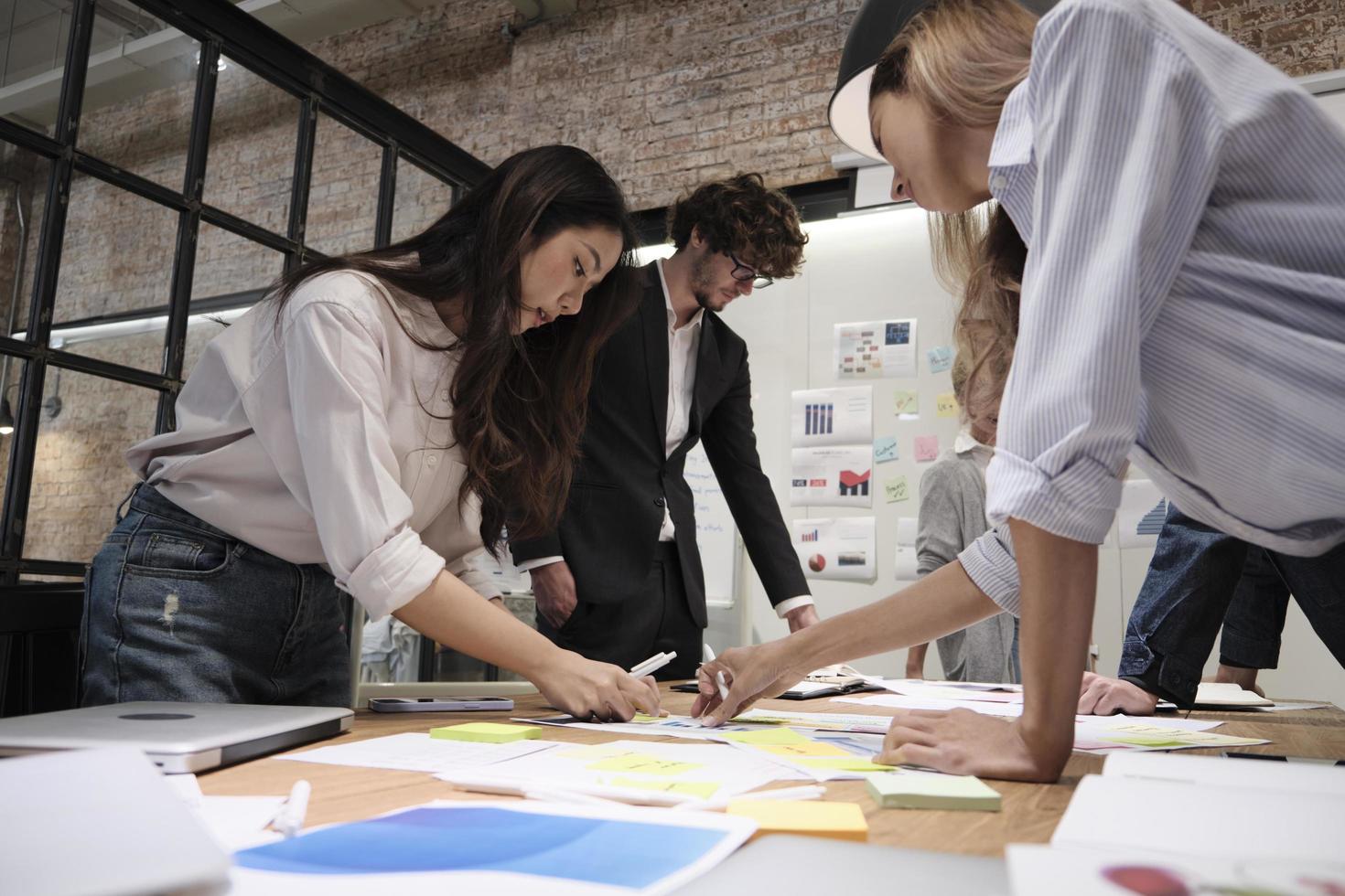 a equipe de colegas de trabalho e o colega fizeram um brainstorm, discutindo uma estratégia de marketing, colaboração de ideias e planejamento de projeto de negócios em uma mesa de conferência de escritório no local de trabalho de reunião de equipe. foto