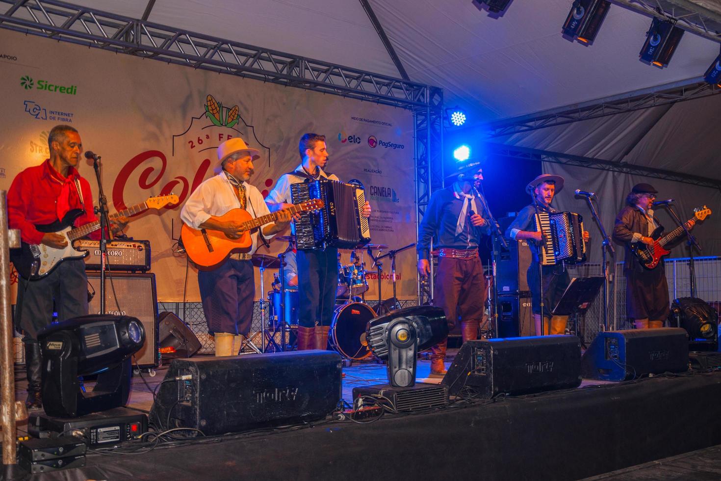 canela, brasil - 21 de julho de 2019. músicos com roupas típicas cantando canções tradicionais em palco de festival folclórico em canela. uma pequena cidade charmosa muito apreciada pelo seu ecoturismo. foto
