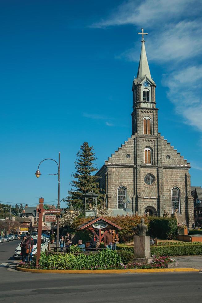 gramado, brasil - 21 de julho de 2019. fachada de igreja com campanário e povoado na avenida borges de medeiros, principal rua de gramado. uma linda cidade de influência europeia, muito procurada por turistas. foto