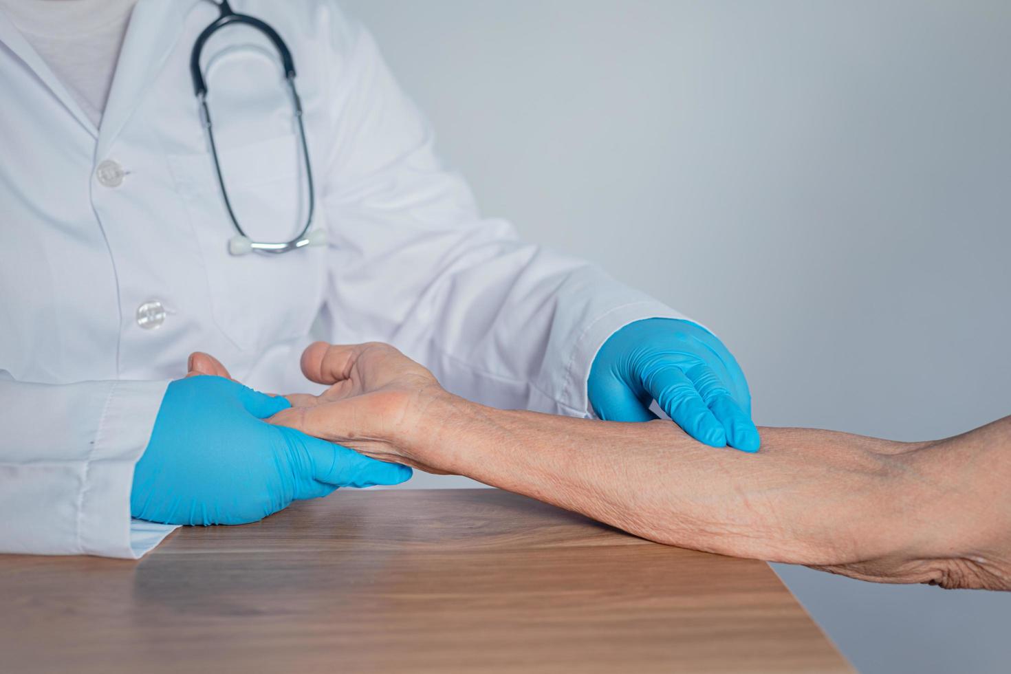 o médico está medindo o pulso do paciente em seu braço. foto