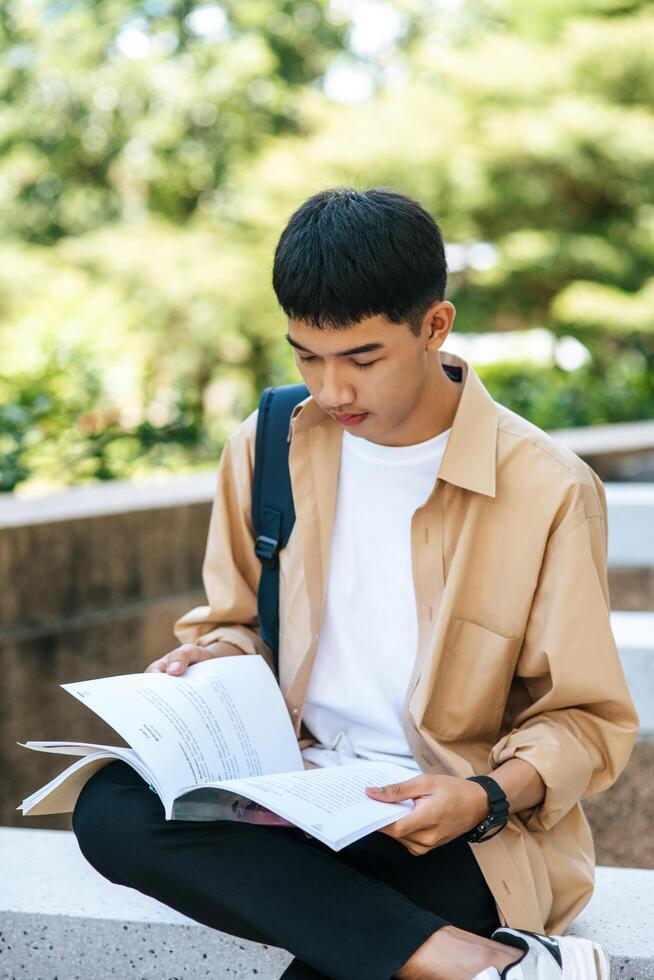 um homem sentado e lendo um livro nas escadas. foto