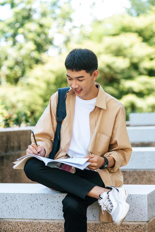 um homem sentado e lendo um livro nas escadas. foto