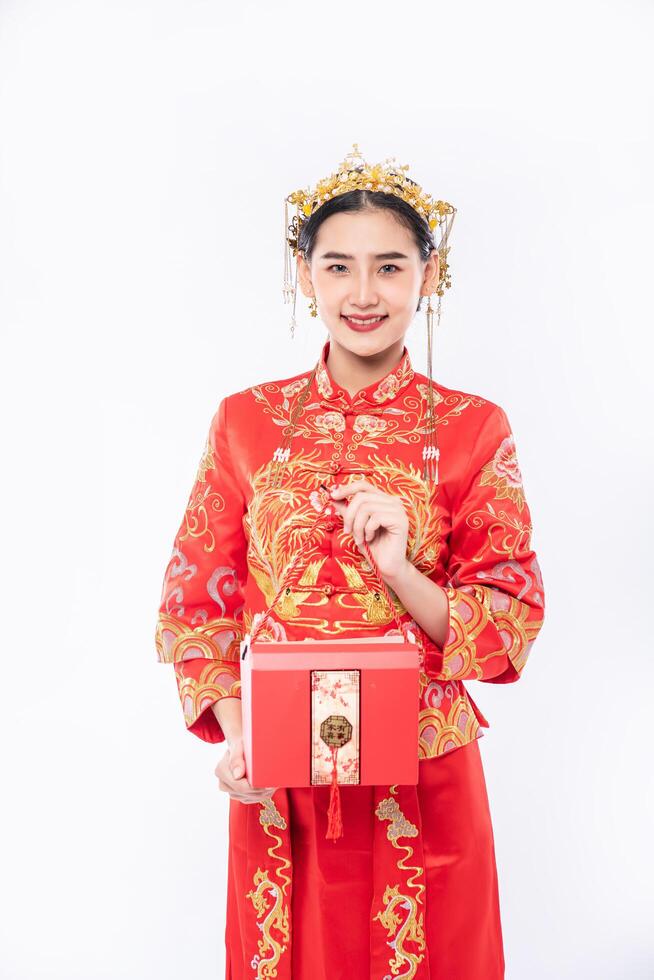 mulher usa terno cheongsam pronto para dar uma bolsa vermelha para a irmã por surpreender nos dias tradicionais foto