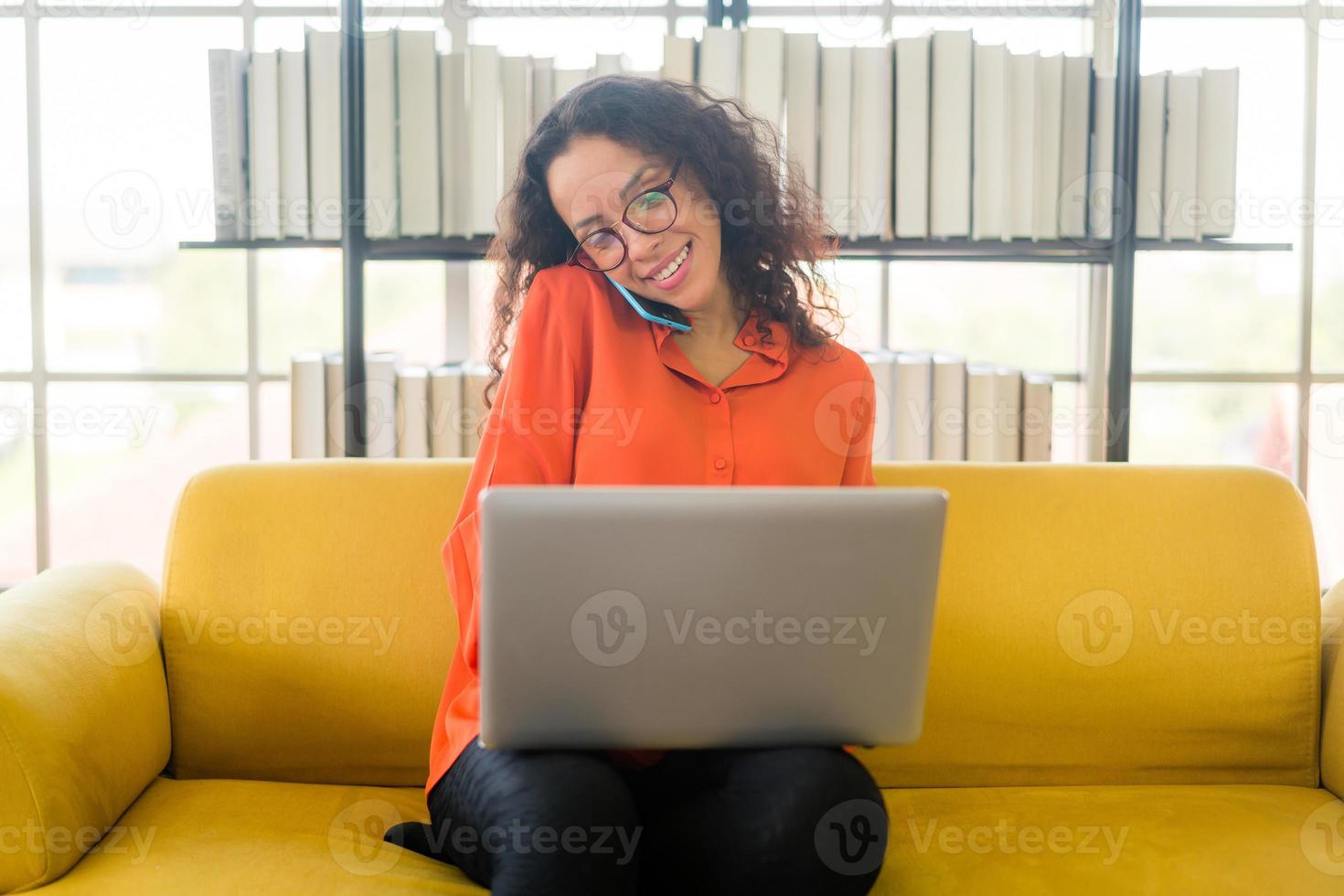 mulher latina trabalhando com laptop no sofá foto