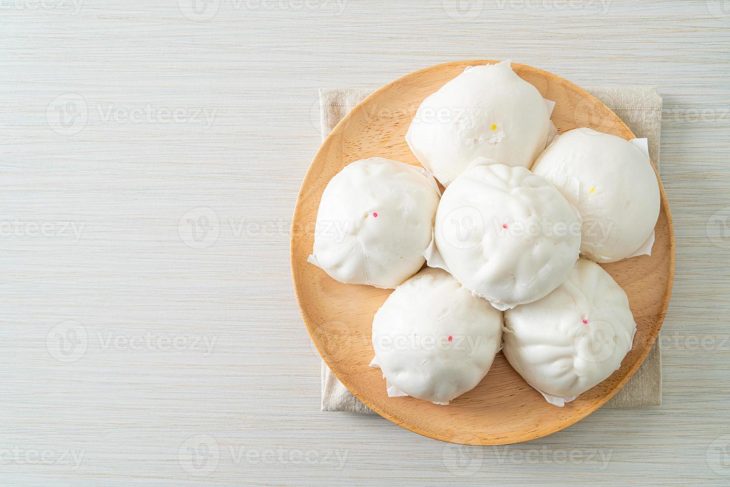 Pão recheado cozido no vapor em prato de madeira foto