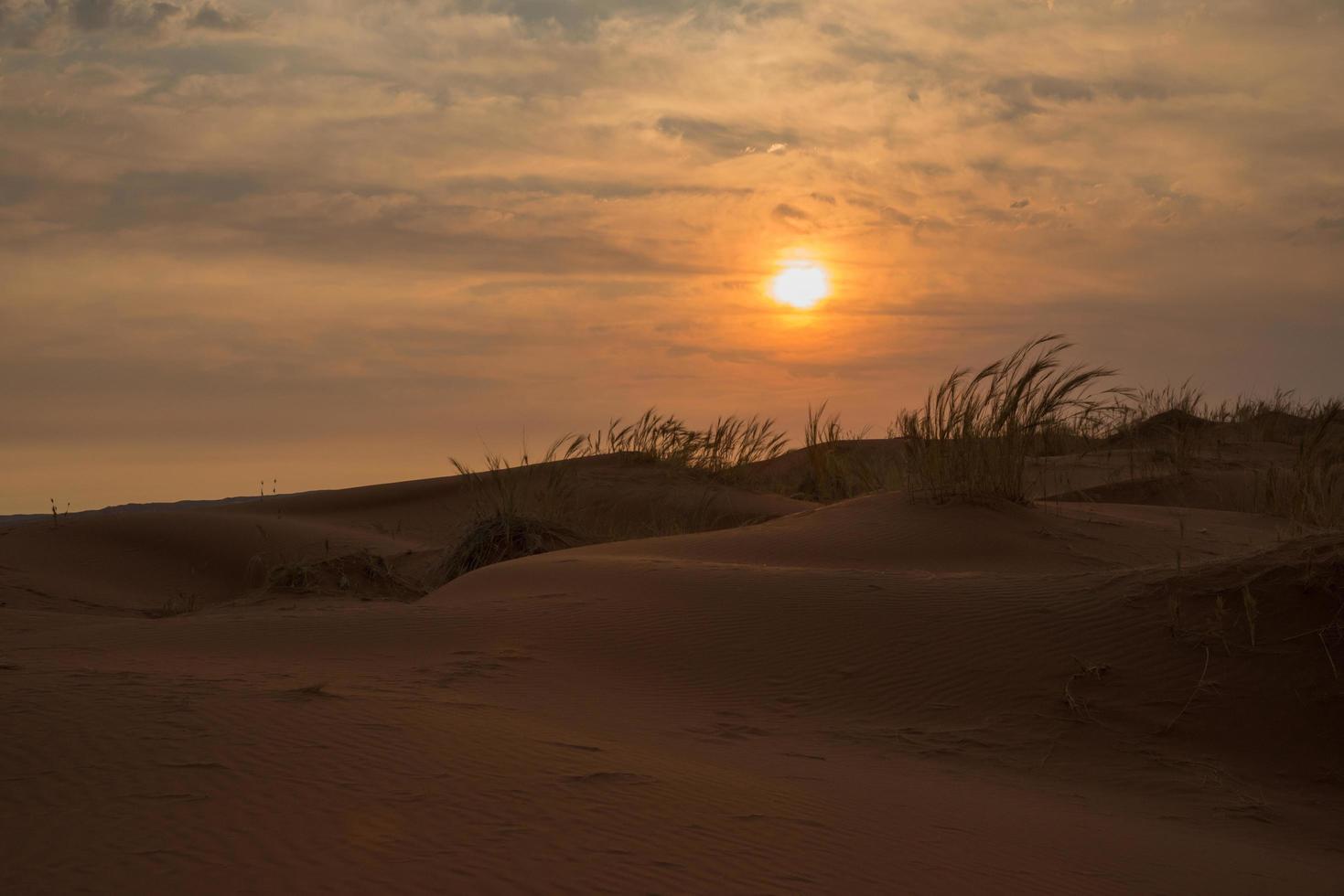 belo pôr do sol no deserto do namibe. céu laranja, sem pessoas. namibia foto