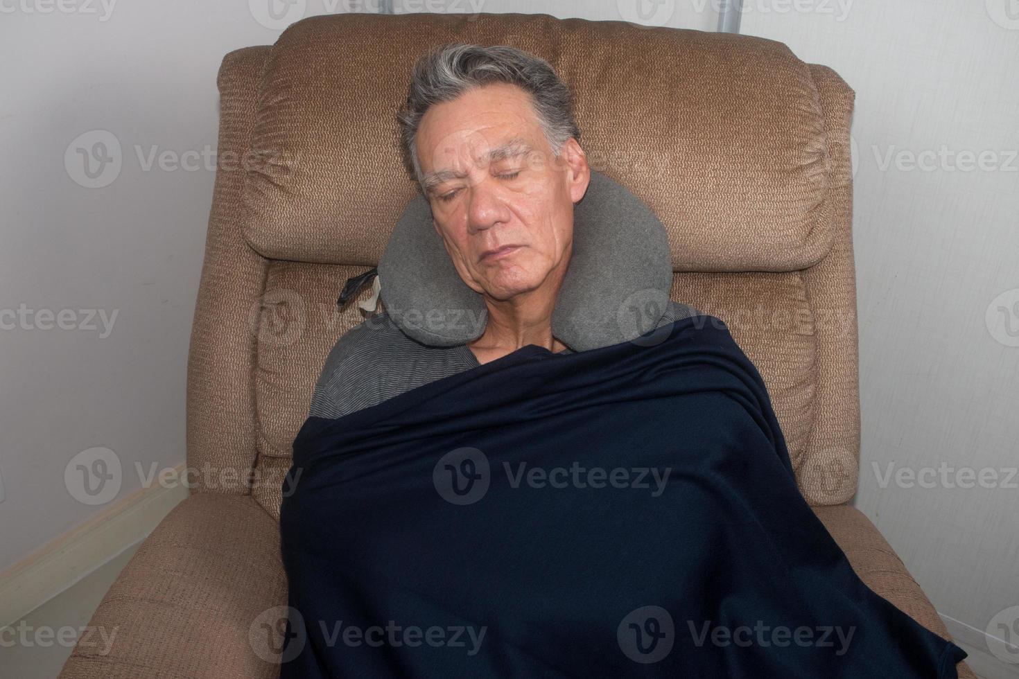 homem maduro tirando uma soneca no meio do dia em uma poltrona foto
