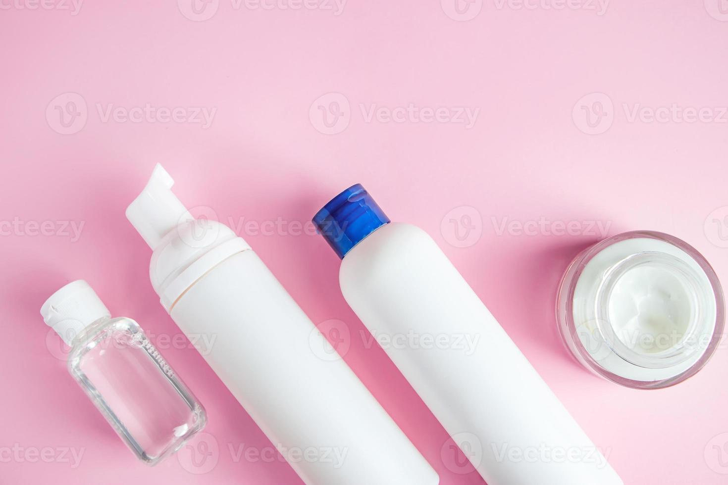 conjunto de cosméticos para cuidados com a pele e limpeza em fundo rosa. foto