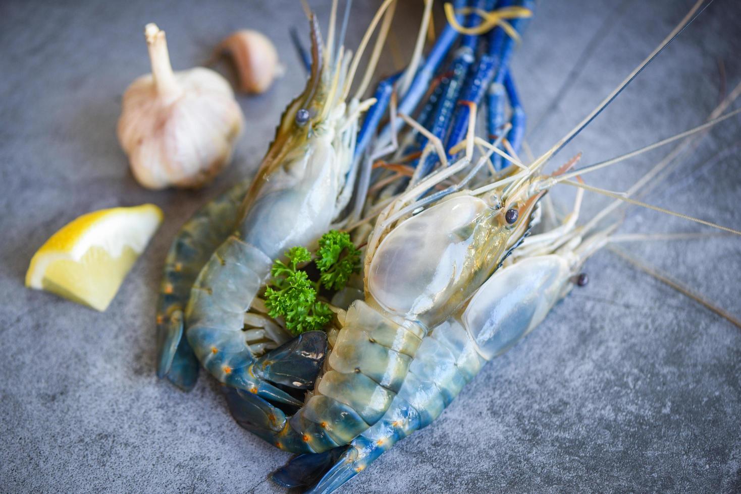 camarão fresco camarão com especiarias, limão e alho para cozinhar em fundo escuro no restaurante de frutos do mar - camarões crus foto