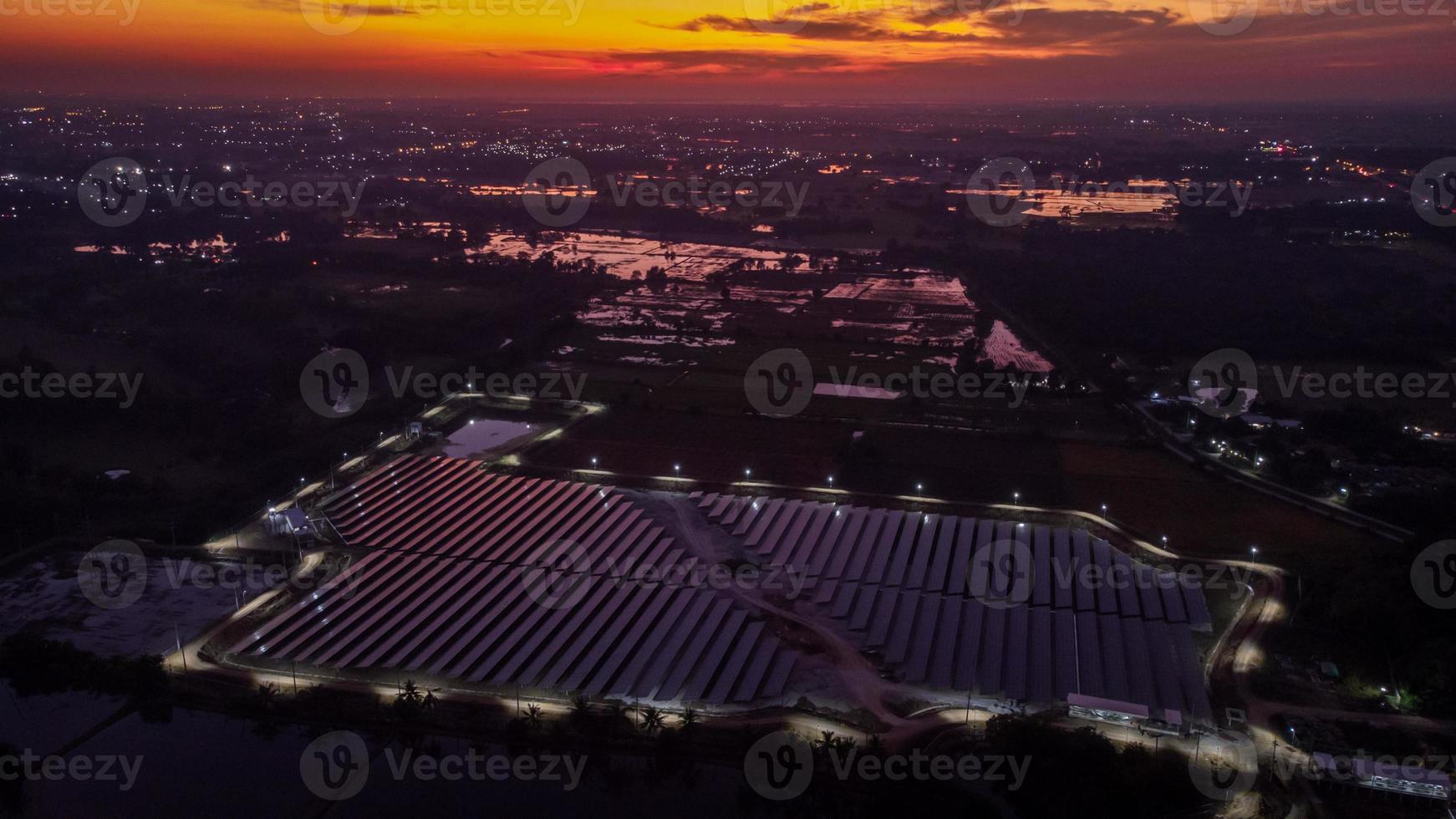 vista aérea de uma fazenda solar produzindo energia limpa durante a noite com o crepúsculo e visível em toda a área foto