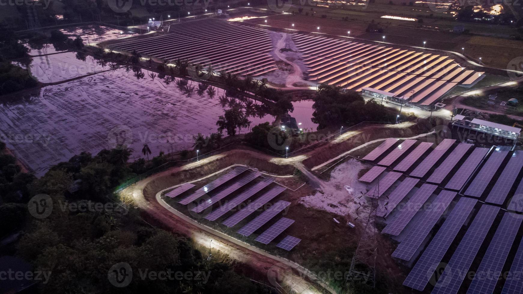 vista aérea de uma fazenda solar produzindo energia limpa durante a noite com o crepúsculo e visível em toda a área foto