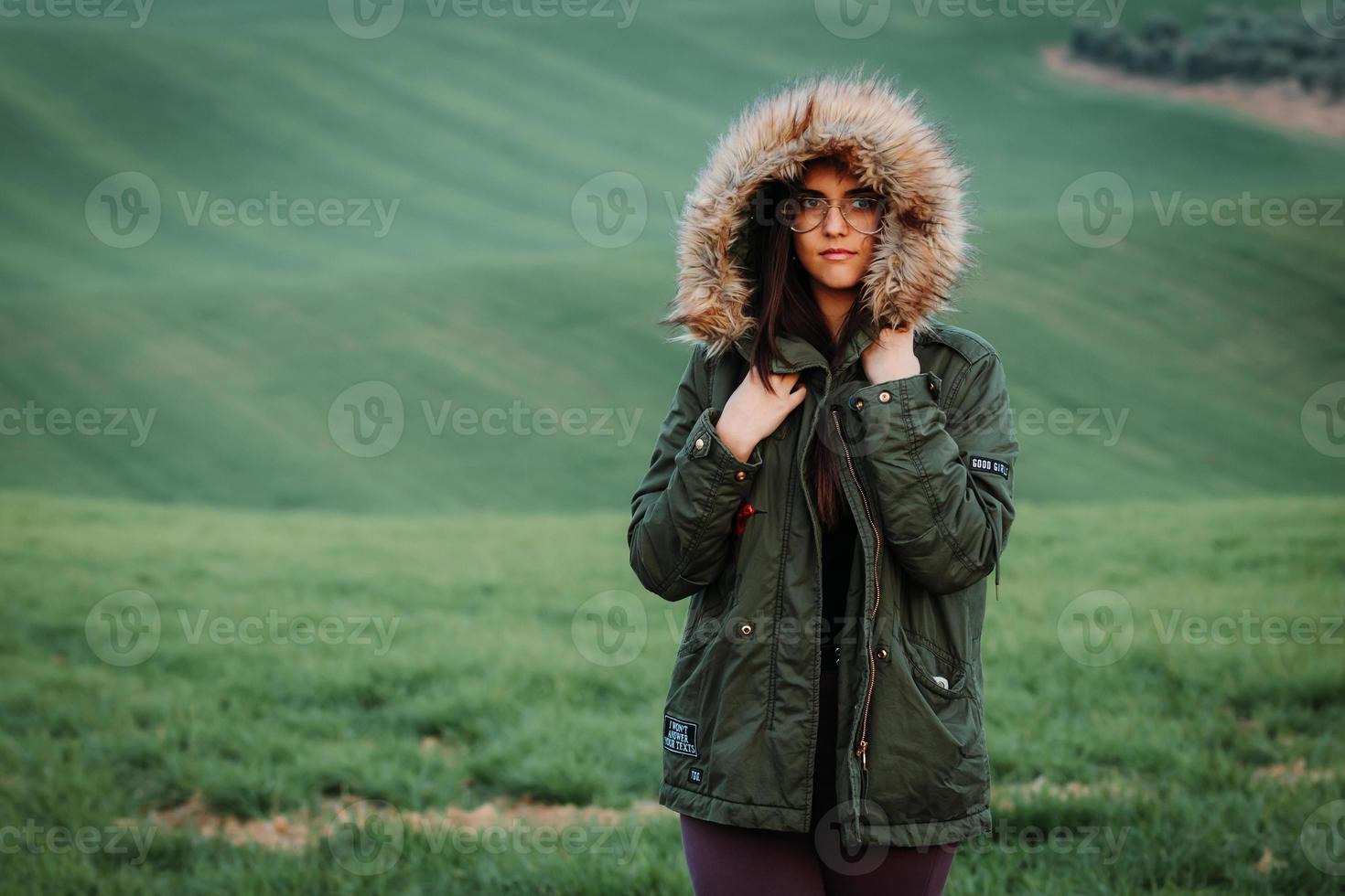 retrato de uma mulher com frio no inverno em um prado verde foto