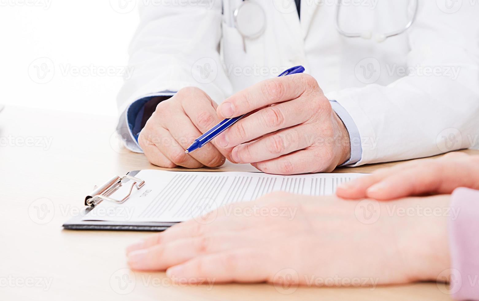 médico e paciente estão discutindo algo, apenas mãos à mesa, seguro médico. foto