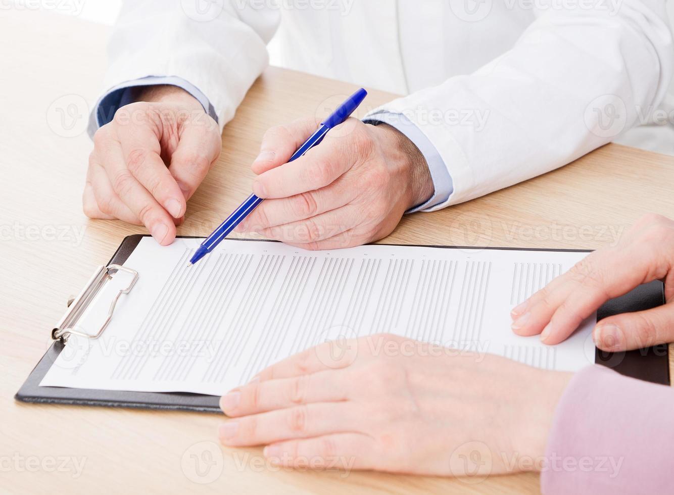médico e paciente estão discutindo algo, apenas mãos à mesa, seguro médico. foto