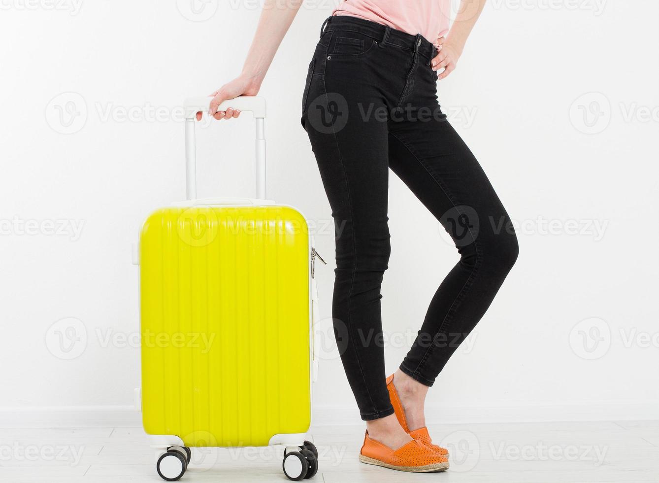 menina com mala amarela isolada no fundo branco. férias de verão. mala de viagem ou bolsa. brincar. copie o espaço. modelo. em branco. foto