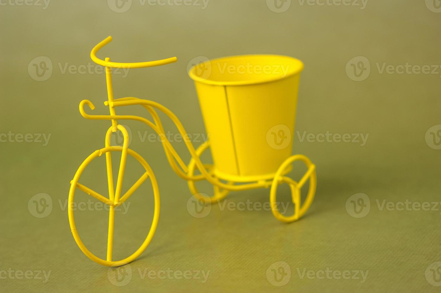 bicicleta de brinquedo de lembrança metálica com um balde em um fundo verde escuro foto