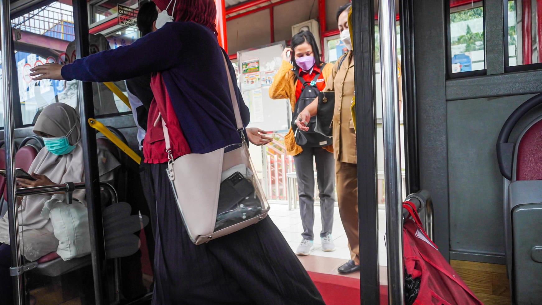 Semarang, Java Central, Indonésia, 2021 - os passageiros entram no transporte público, o sistema de ônibus rápido foto