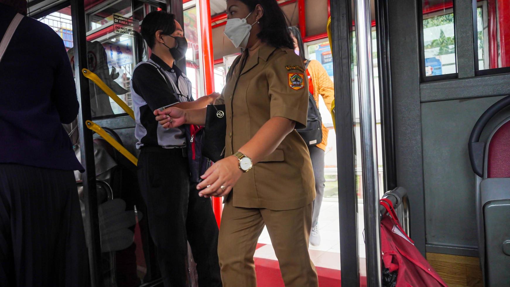 Semarang, Java Central, Indonésia, 2021 - os passageiros entram no transporte público, o sistema de ônibus rápido foto