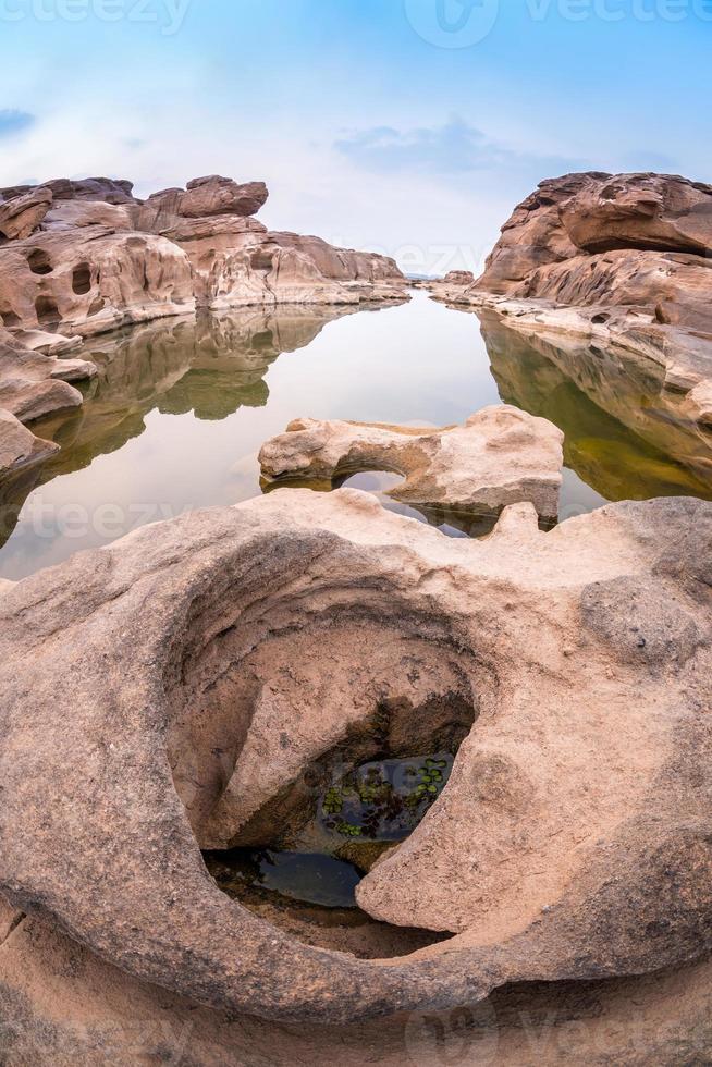 natureza paisagem vista de dunas de areia e campo rochoso com reflexo de água em sam phan bok um canyon junto ao rio mekong no grand canyon da tailândia. foto