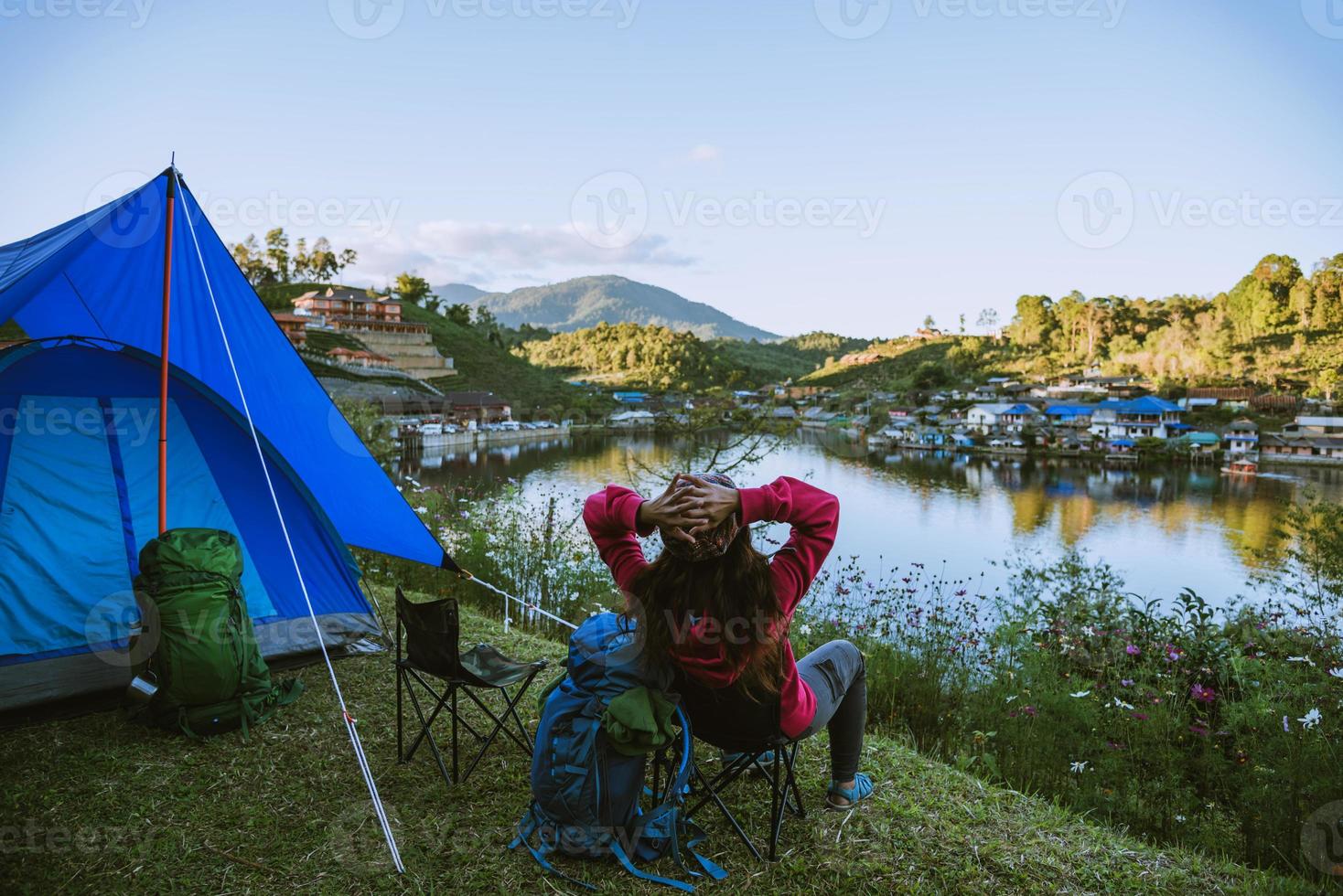 mulher asiática viajar natureza. viajar relaxar, acampando em uma vila rural na montanha, perto do lago. foto