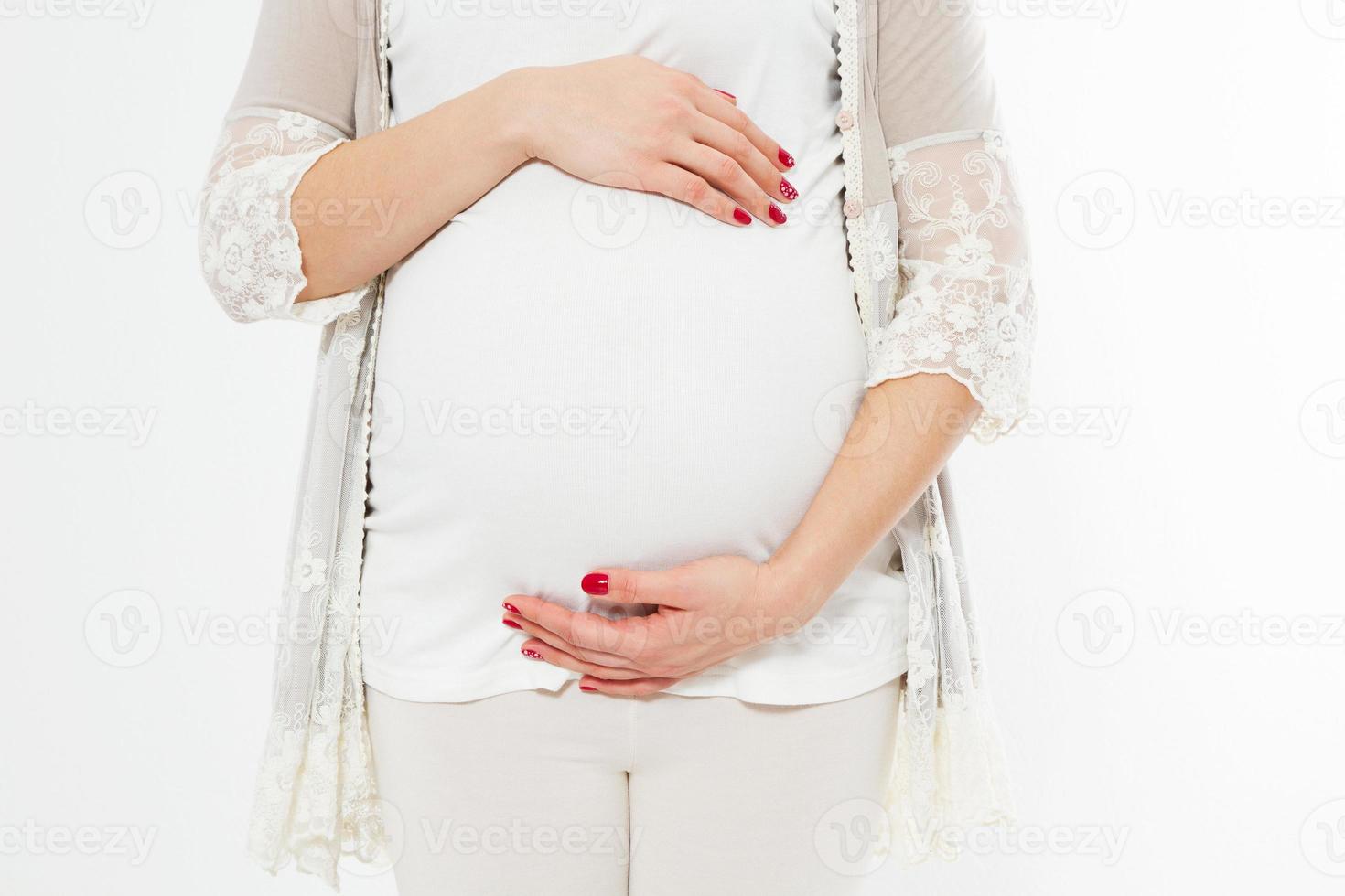 jovem grávida mantém as mãos sobre a barriga inchada. conceito de amor. feliz acontecimento, nascimento de uma criança foto