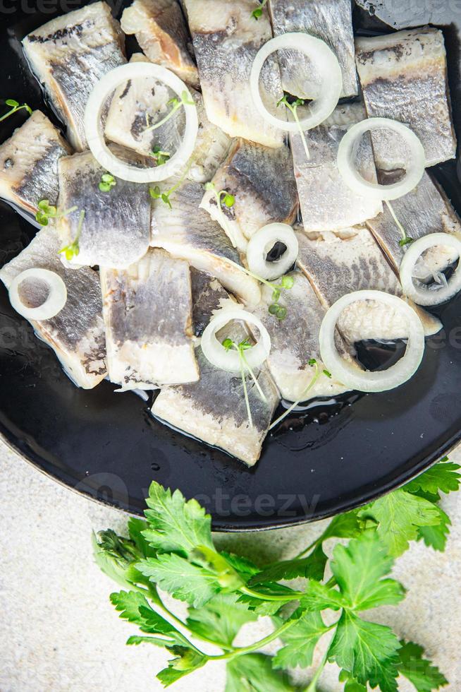 Pedaços de peixe fatia de arenque com cebola frutos do mar refeição saudável dieta pescetarian foto