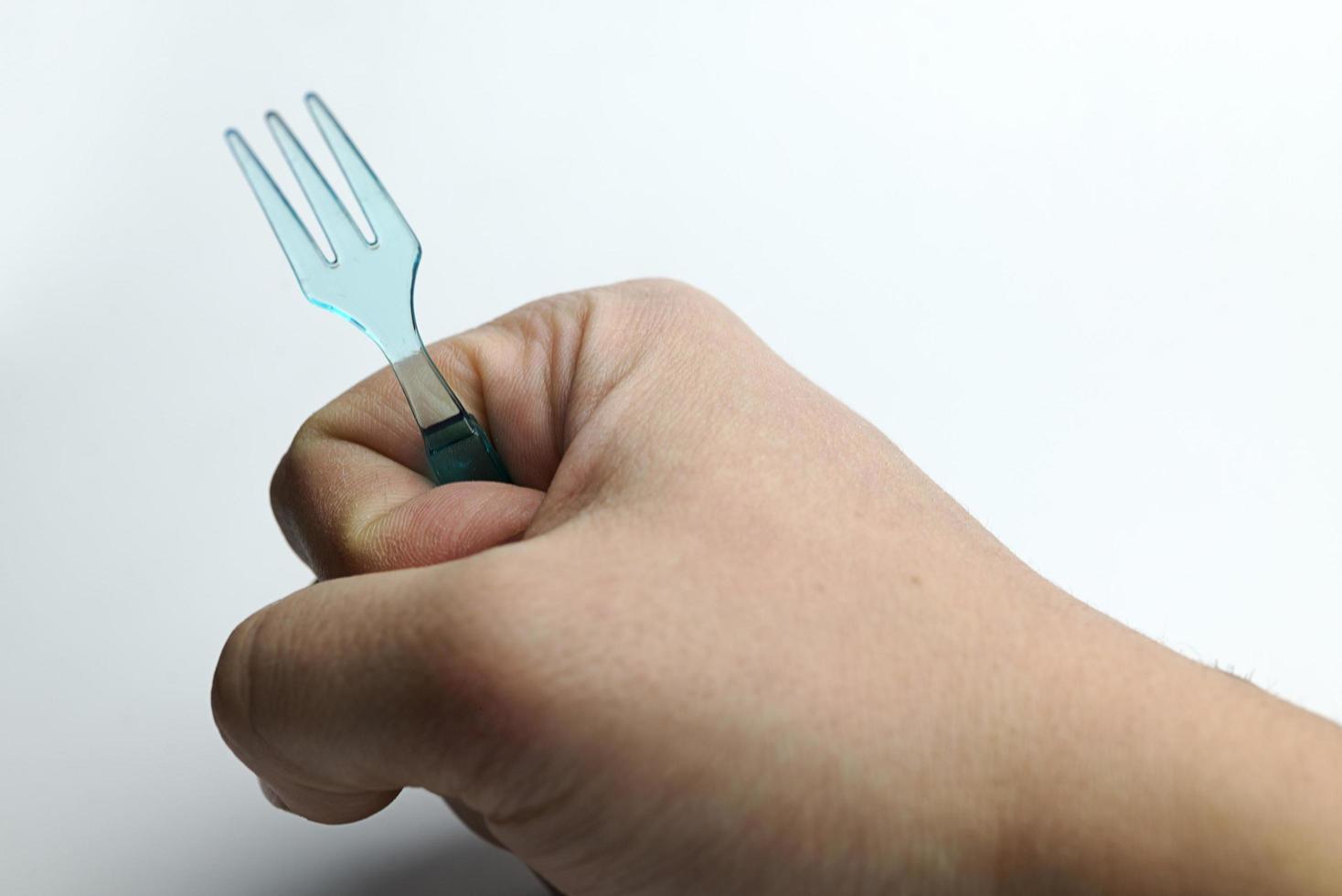 mão segurando um garfo de plástico. foto