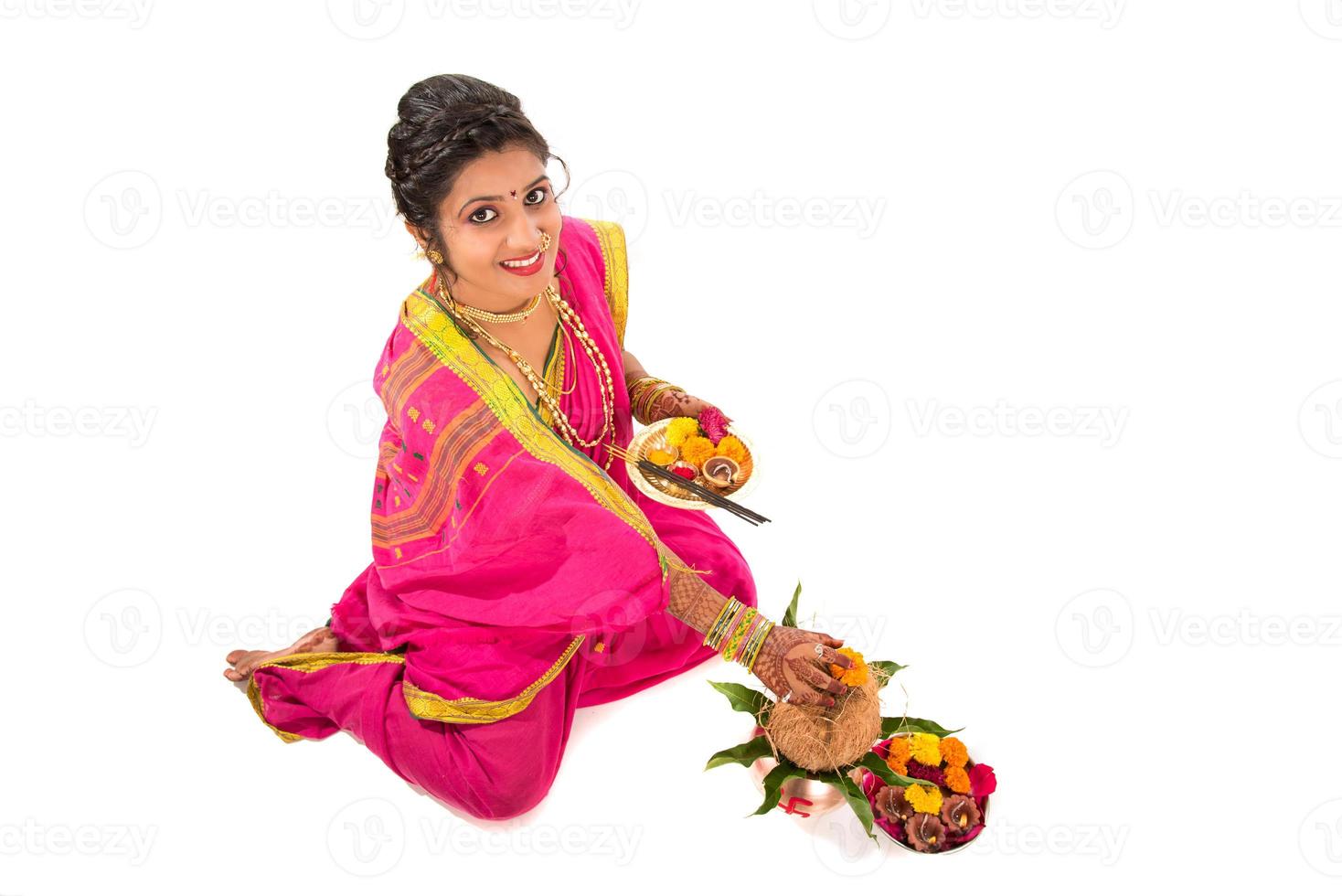 garota tradicional indiana realizando adoração com kalash de cobre, festival indiano, kalash de cobre com coco e folha de manga com decoração floral, essencial no puja hindu. foto