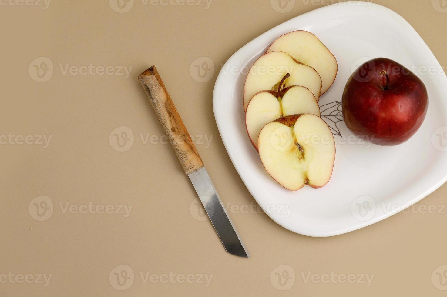 deliciosa maçã e fatia em prato branco com faca e garfo foto